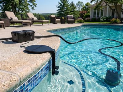 Pool Guardian installed on a pool: controller on the deck, sensor mount on the coping, drain pump in the water